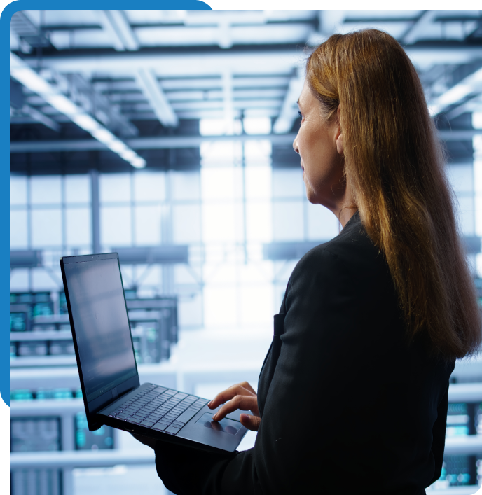 IT professional with a laptop in a data center, supporting Bamshaw's federal application and database sustainment and modernization