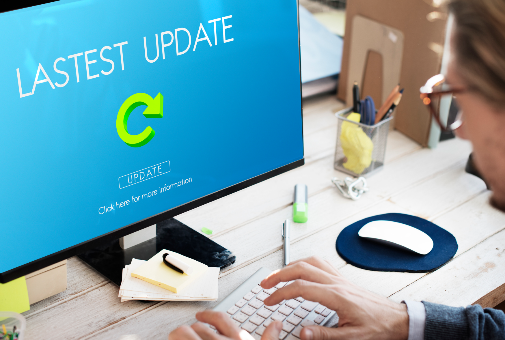 Person at a desk viewing a software update screen, representing Bamshaw's periodic software upgrade services