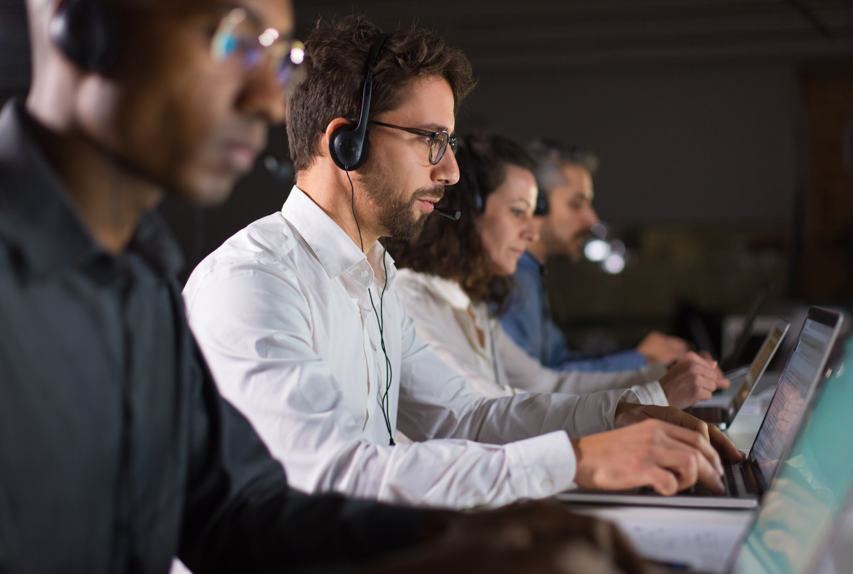 Support team wearing headsets working at laptops, representing Bamshaw's technical support and software troubleshooting services